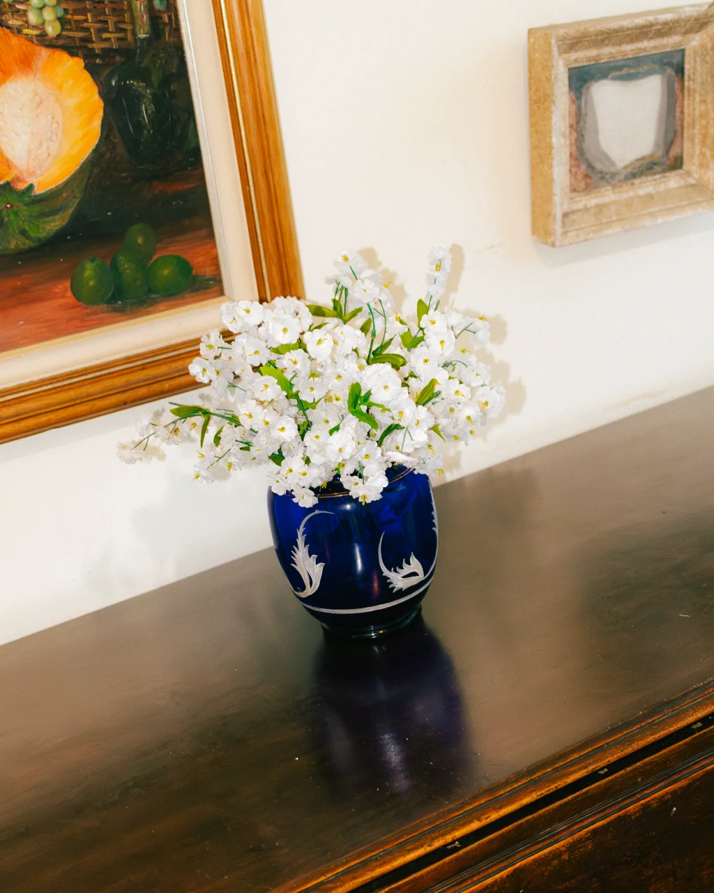 Vaso azul com flores brancas sobre console de madeira, Hotelinho da Urca