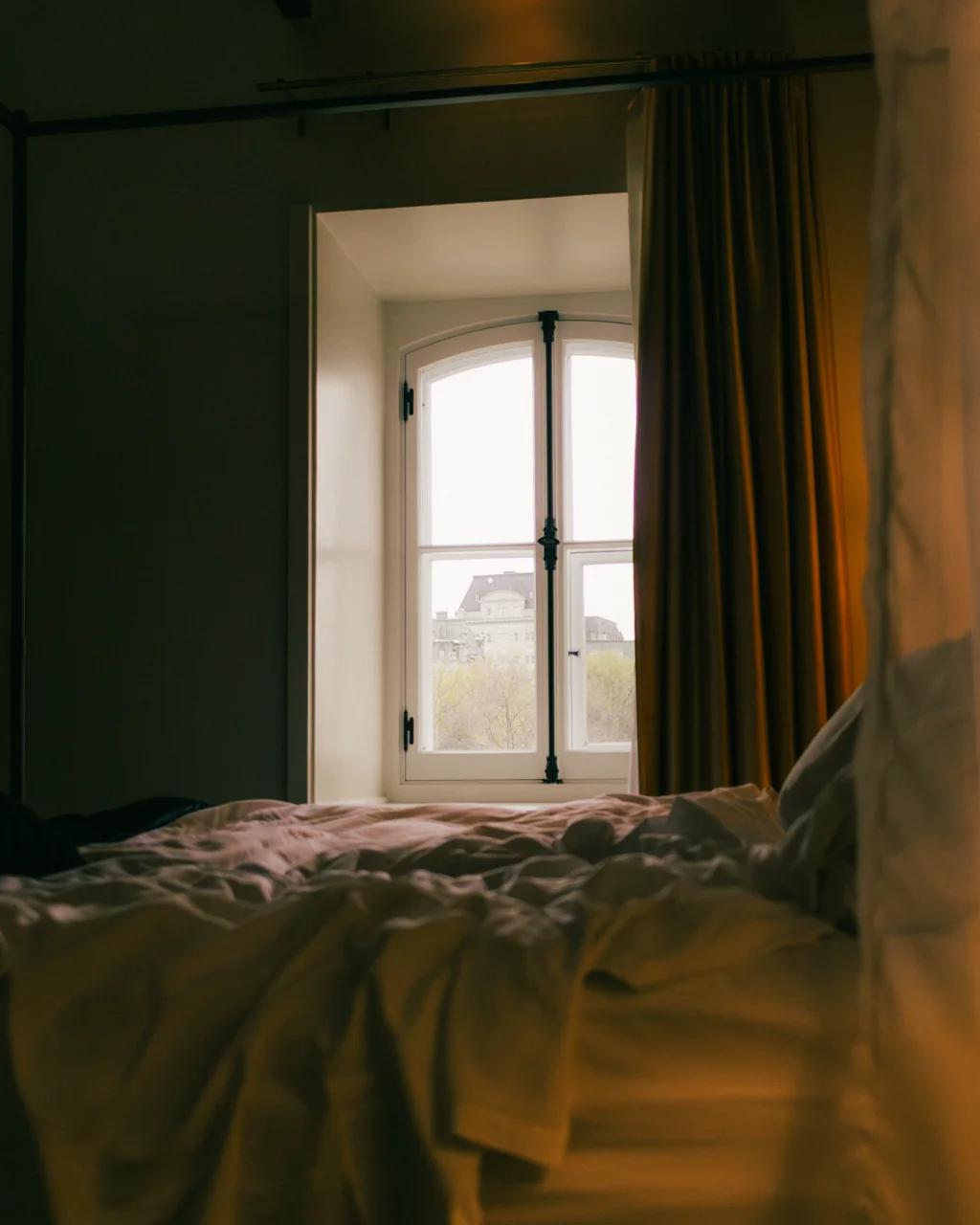 Quarto com janela em arco e vista da cidade ao amanhecer no Manoir d'Auteuil, Quebec City